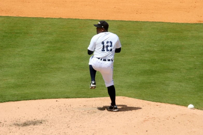 a baseball pitcher throwing the ball on a field