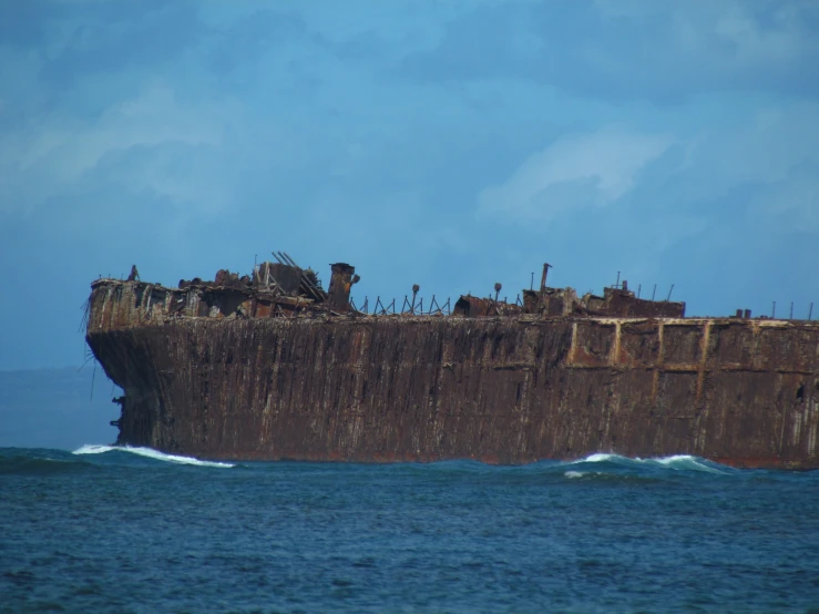 an old ship sits in the ocean with strong waves