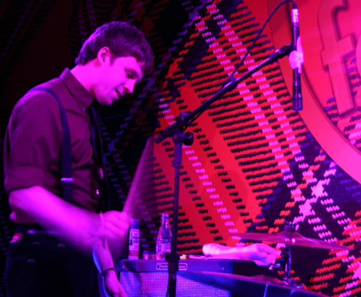 a man playing a piano in front of a microphone