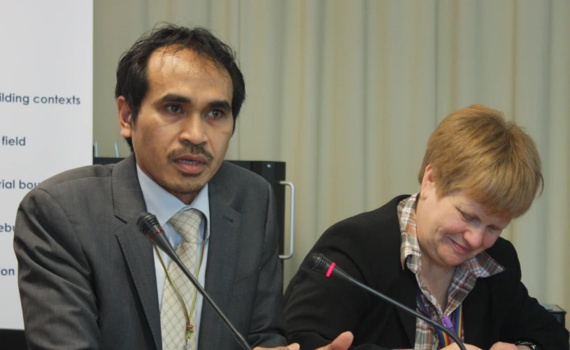 two people wearing ties sitting at a table