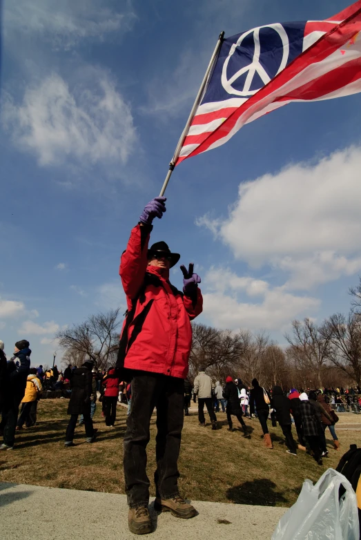 a woman holding an american flag in front of a large crowd