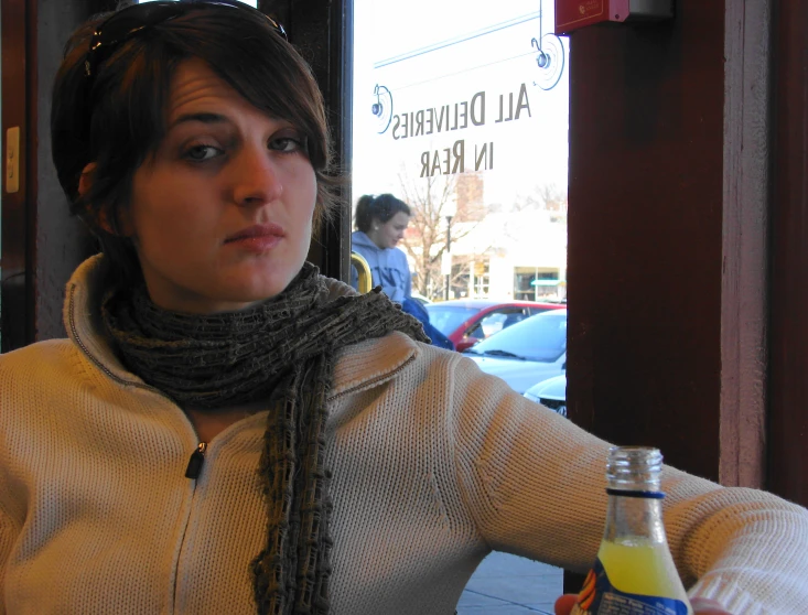 a women holding up a bottle of orange juice