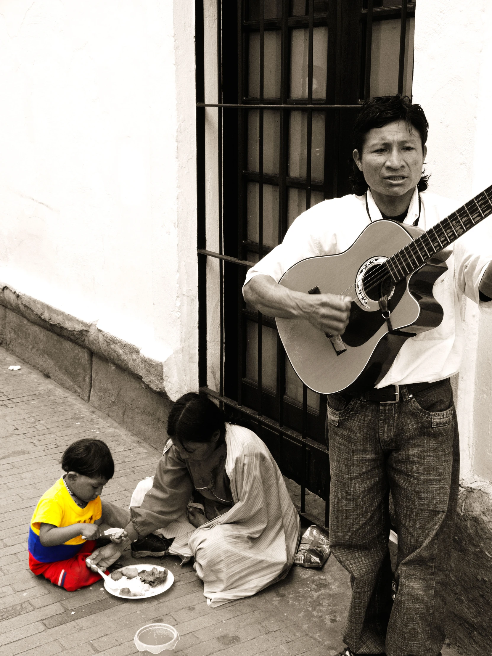 a man plays the guitar outside of his home