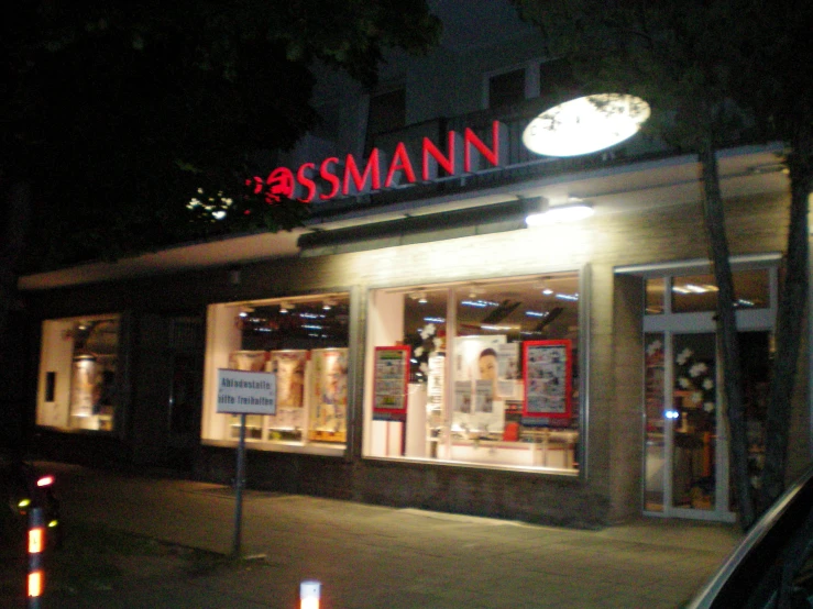 the sign for ass mann in a store at night