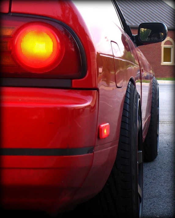 the rear view of a red car, seen from the side