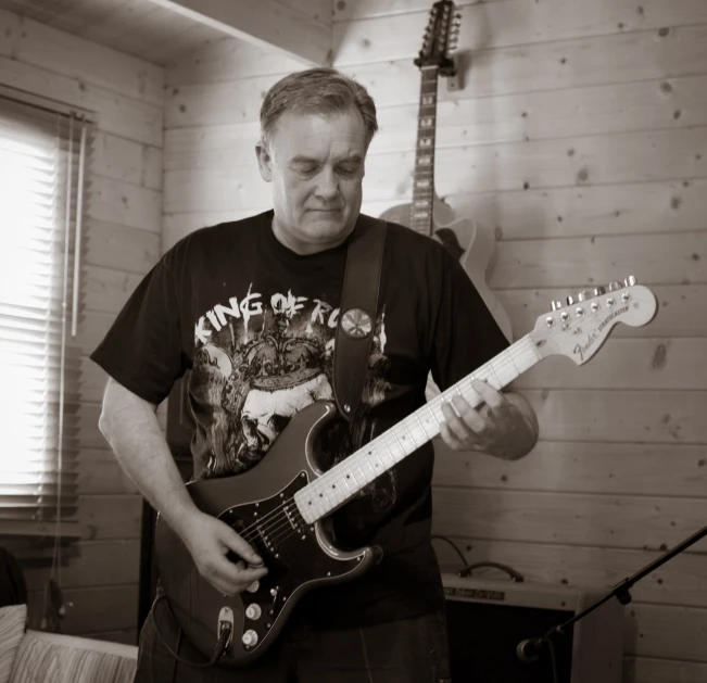 a man is playing a guitar inside the room