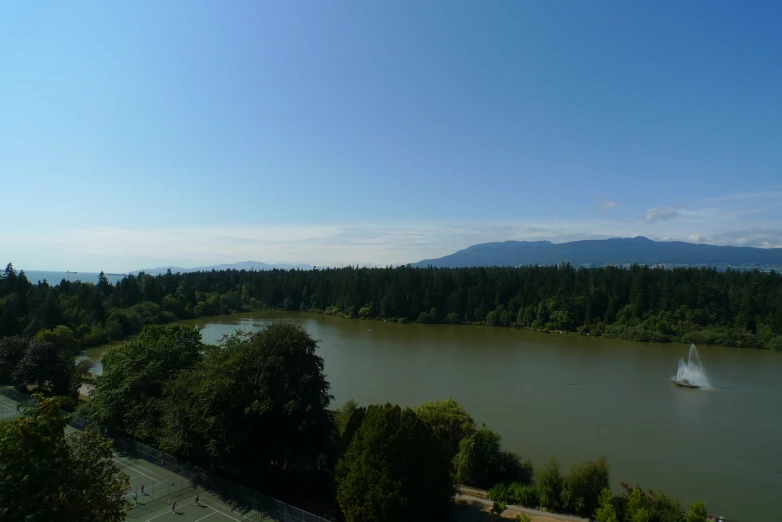 an aerial view of a large lake with trees and mountains