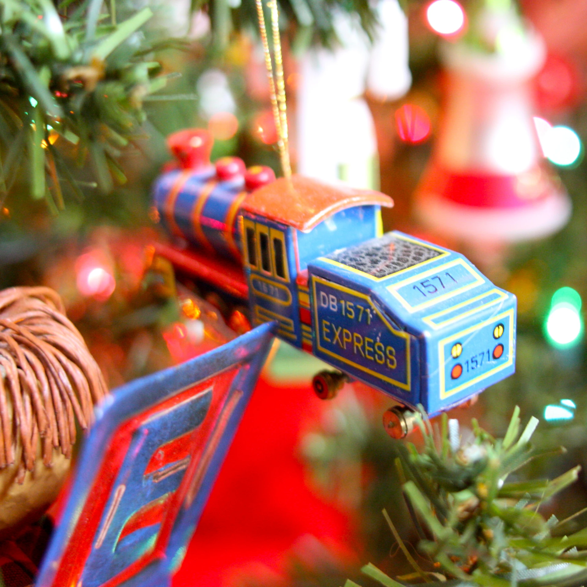 a toy train sits on the christmas tree ornament