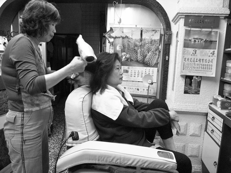two women are doing hair styling in a salon