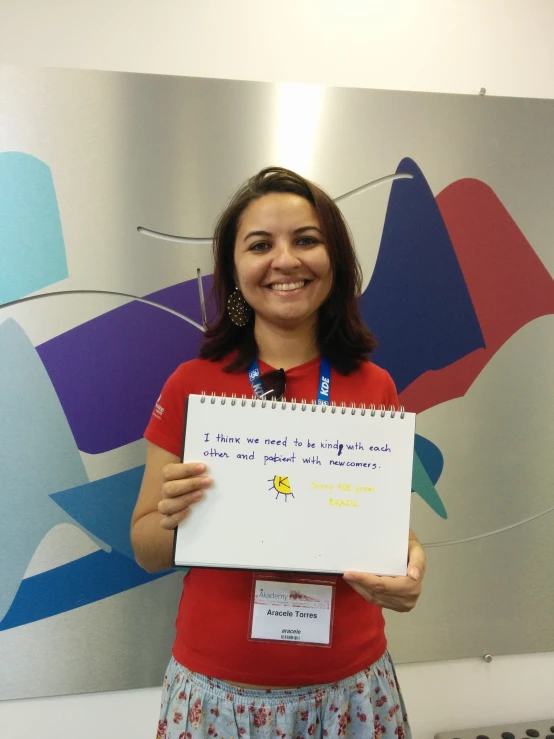 a young woman holding up a white paper with words on it