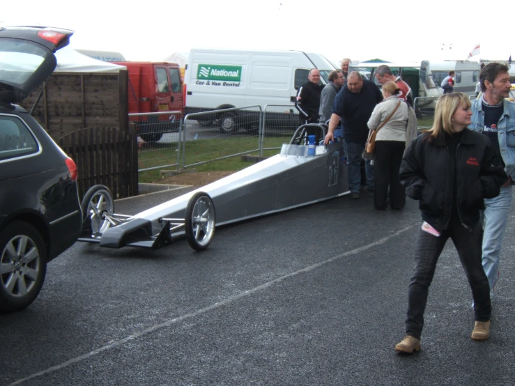 the woman is walking next to an upside down car