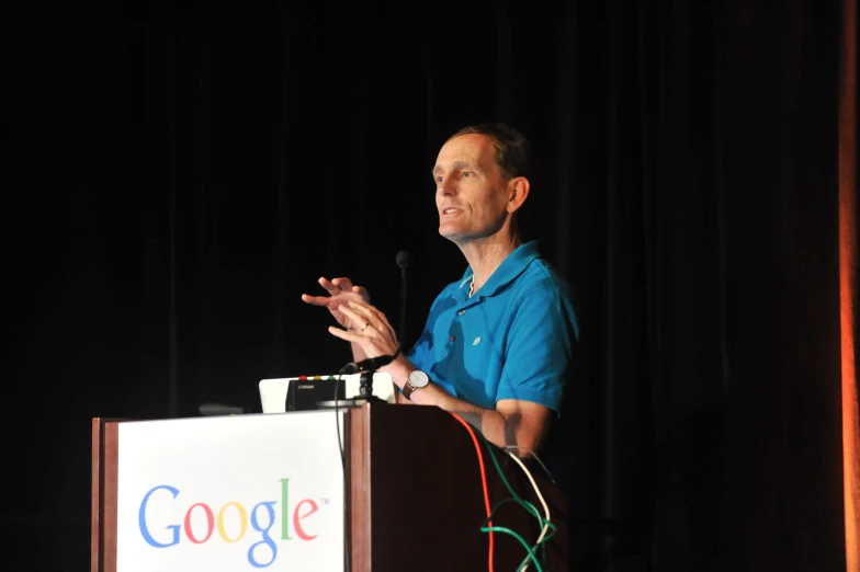 an man giving a speech at google's annual conference