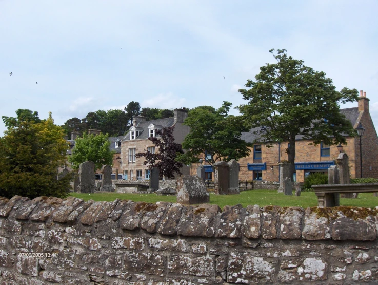 a stone fence surrounds an old cemetery