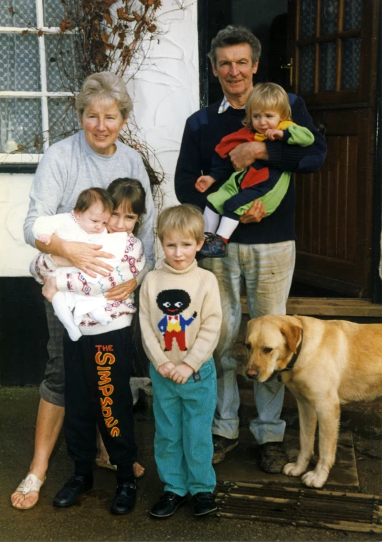 a family and their dog standing on front of the door