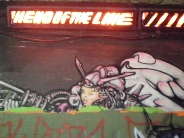 a street sign that says end of the line with a graffitti of a woman on it