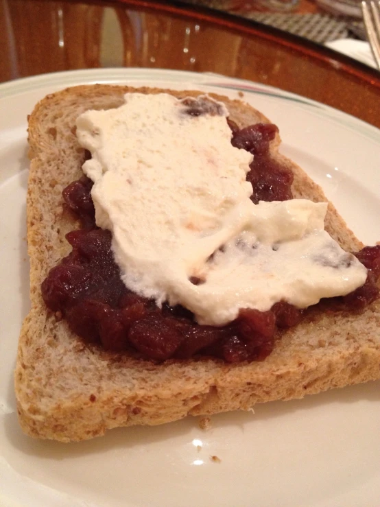 sandwich on a white plate with ice cream on top