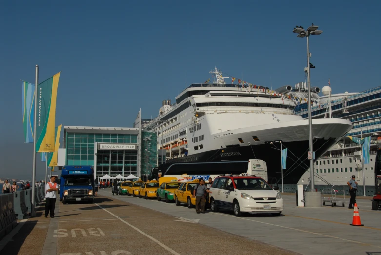 cars and trucks in front of a cruise ship