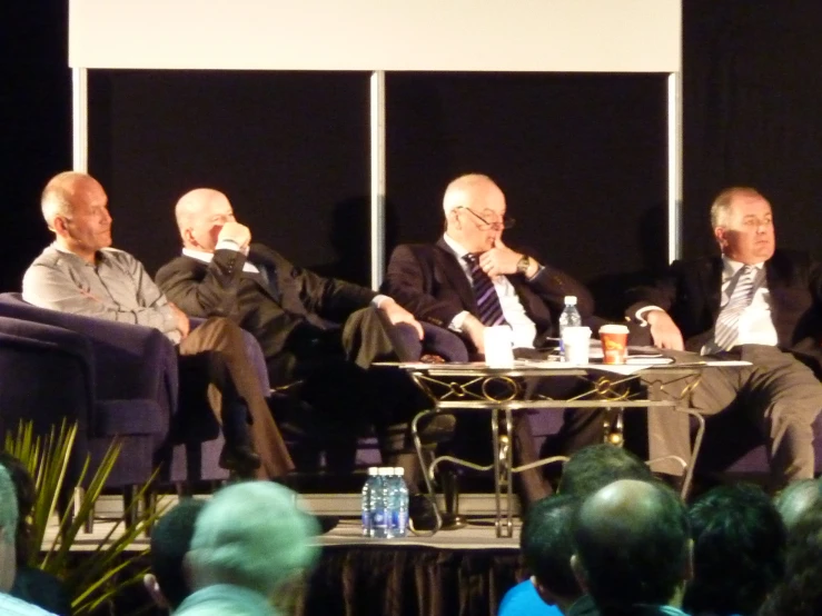 men sitting around a table, having a conversation