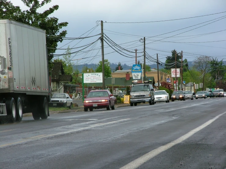 several cars stopped at an intersection on the busy road