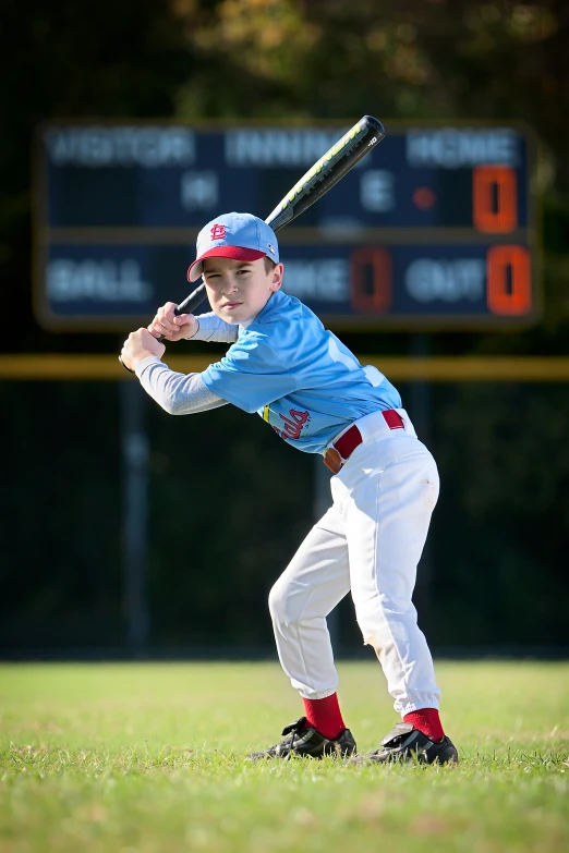 a young man swinging a baseball bat on top of a field