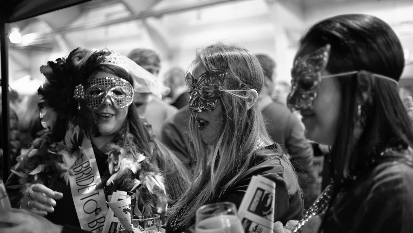 two beautiful women dressed in silver at a masquerade party