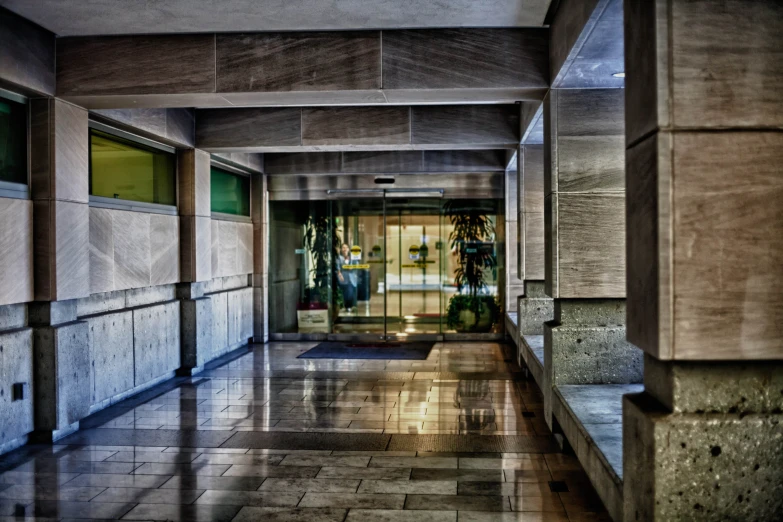 an empty hallway in a building with marble walls and a doorway