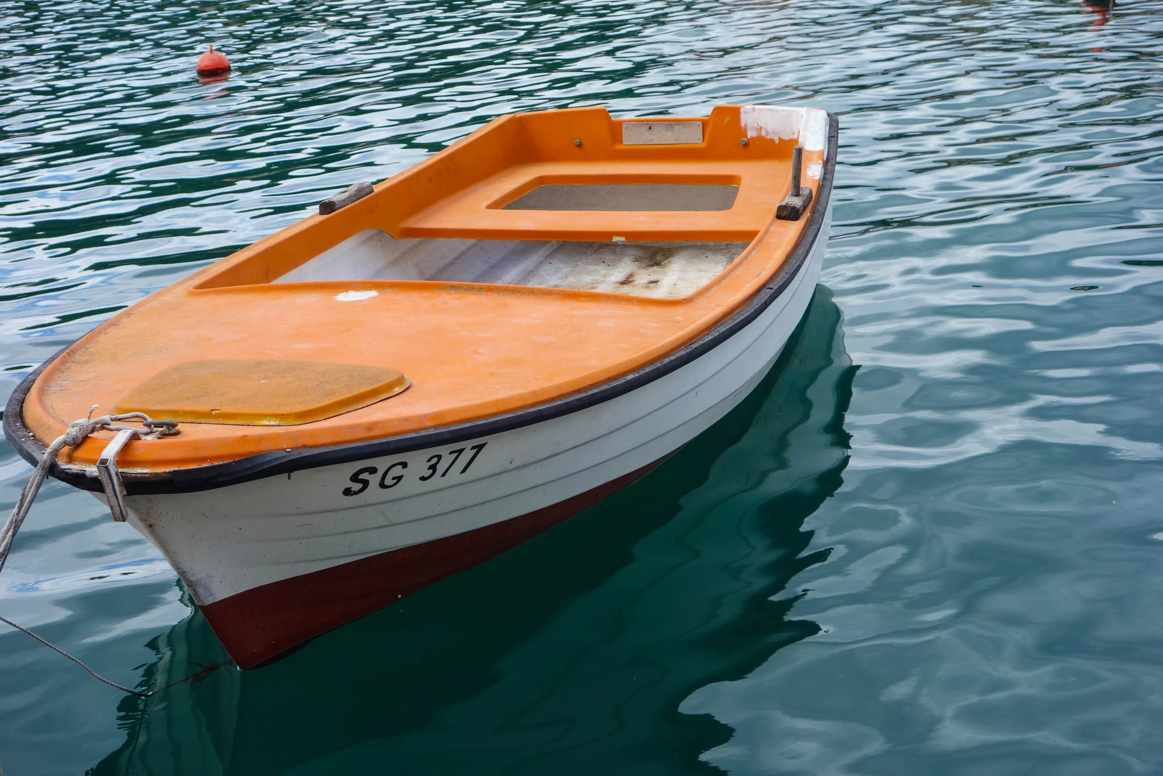 a small boat on the water with its front end tied