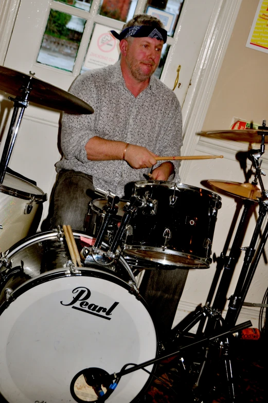 the man is playing his drums in the music room