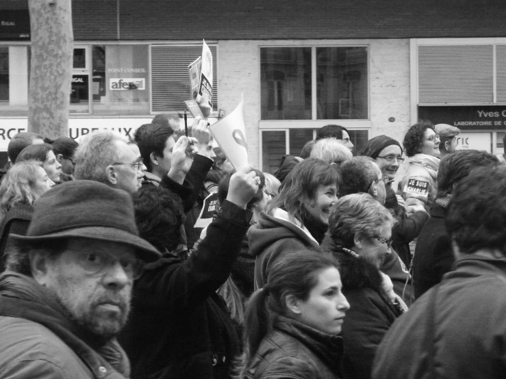 many people in black and white stand outside of a building