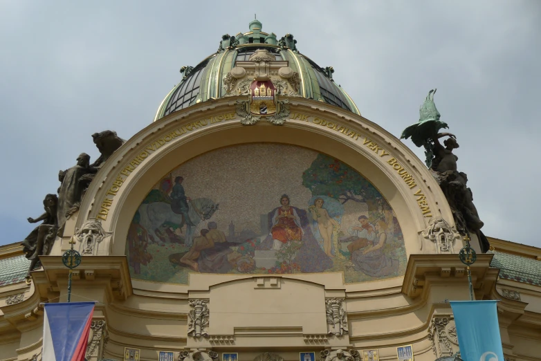 a statue sits below an ornate painted building