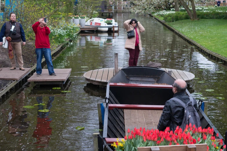 people standing on the dock next to small boats