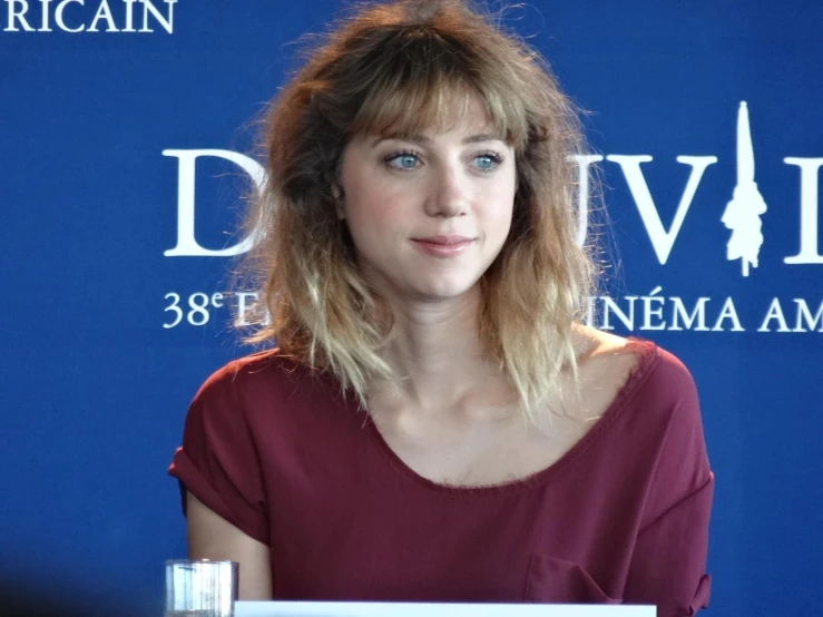 a woman in red shirt at blue carpet event