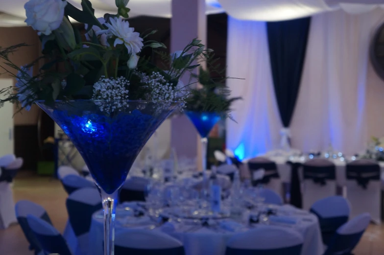 a vase filled with white flowers and greenery