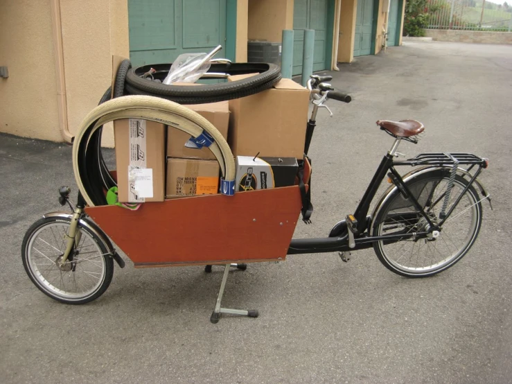 a bike parked outside with cardboard and other boxes in the back