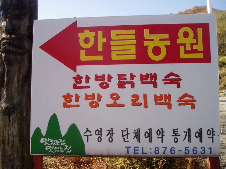 a sign with many languages attached to a wooden pole