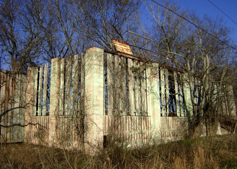 a very old concrete structure near a tree line