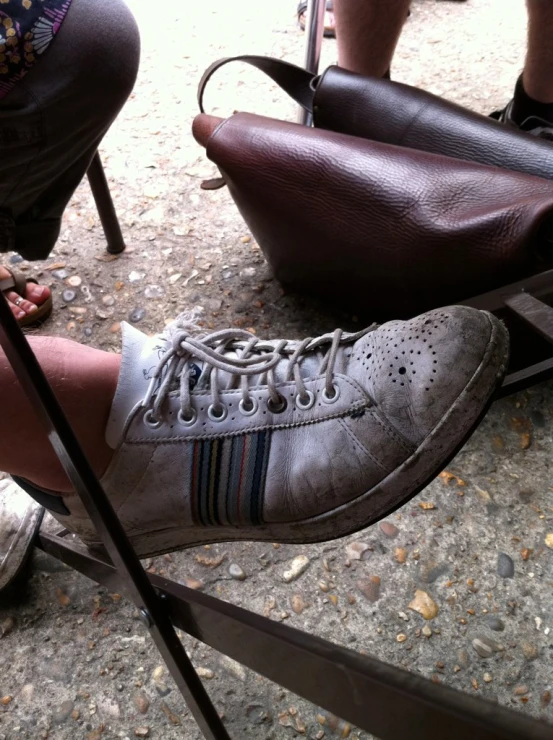 a person wearing a gray shoe and carrying bags