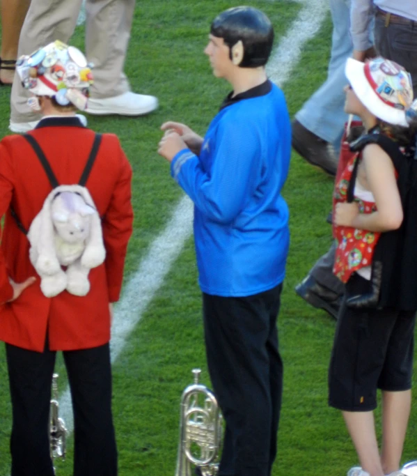 a man in blue jacket next to children with musical instruments