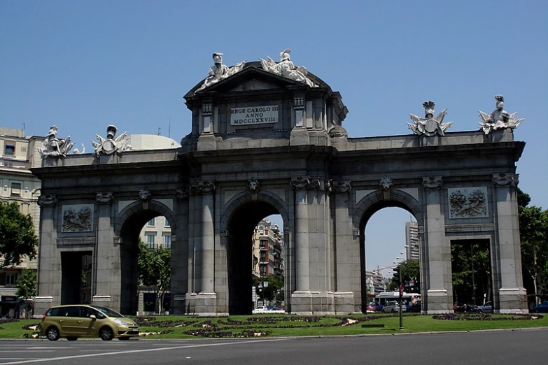 an old arch building in the center of a city