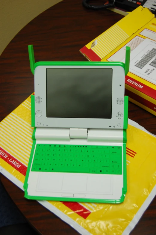 a laptop computer sitting on top of colorful bags