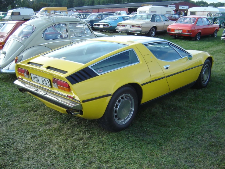 two large yellow mustangs on display at a car show