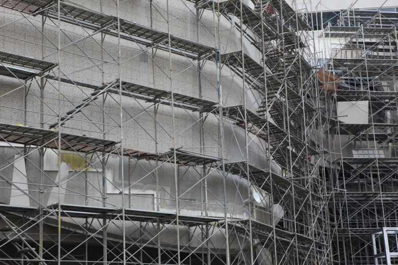 a tall white building with scaffolding around it's perimeter