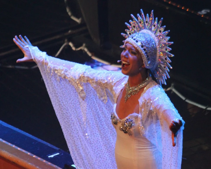 a beautiful woman in costume is performing on stage