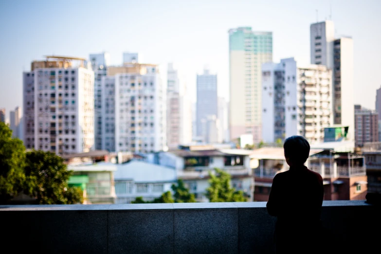 boy looking out over city from the balcony