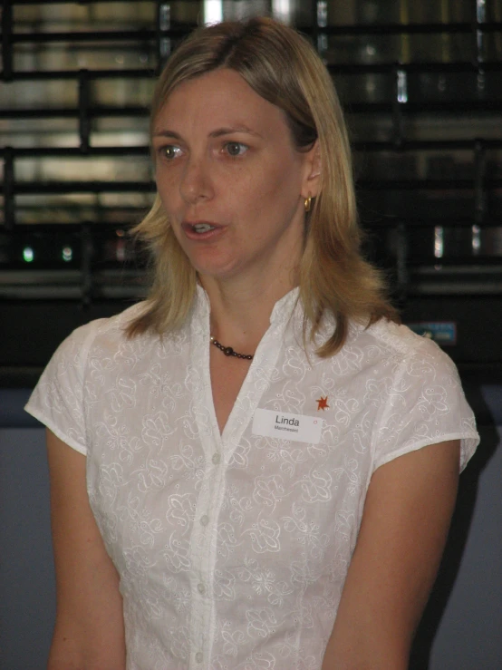a woman in a white shirt with the name on her collar