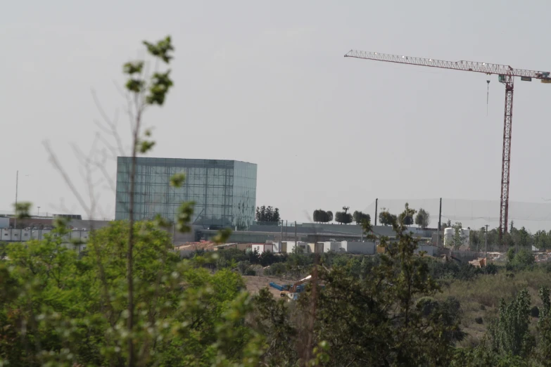 a construction crane in front of a building that has a lot of windows