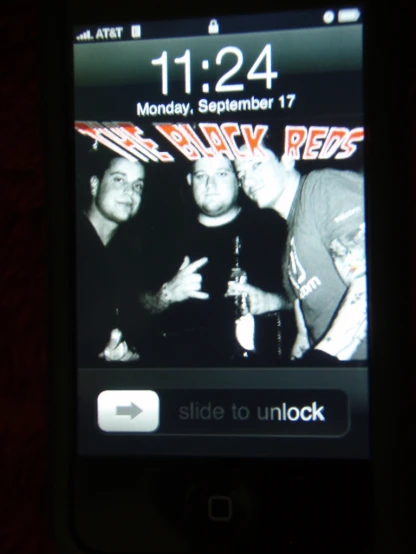 cell phone displaying image of a band on a wall