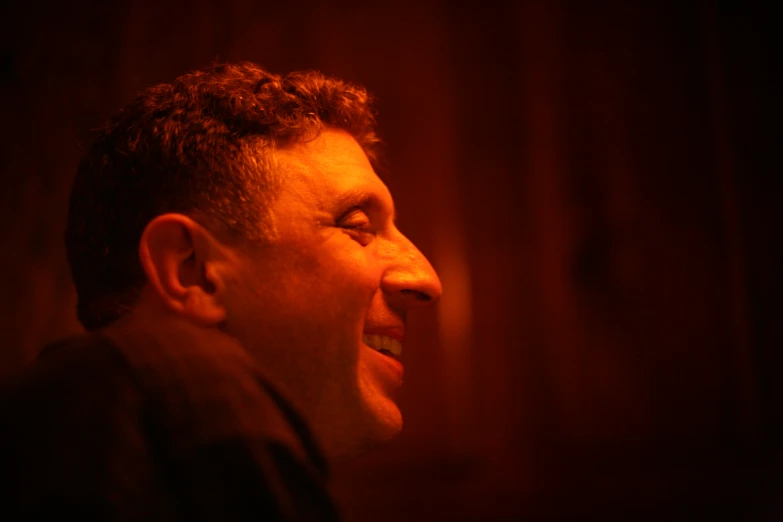 a man in profile at night smiling at soing