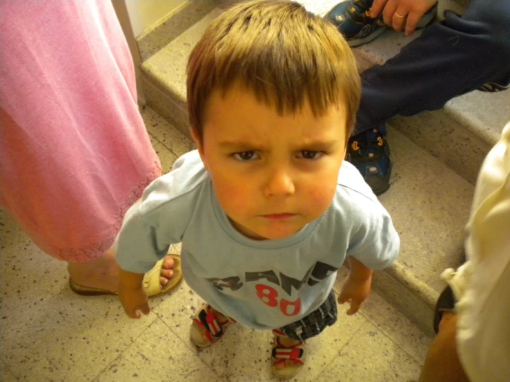 a baby standing on top of cement flooring