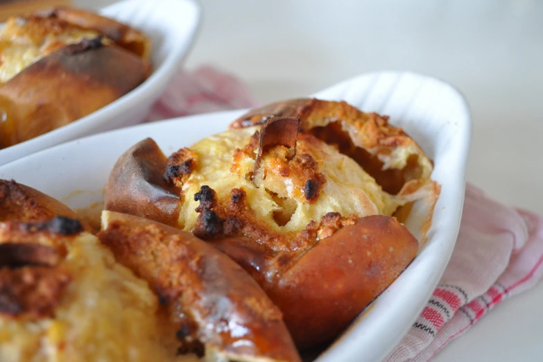 two white bowls filled with sausage and bread